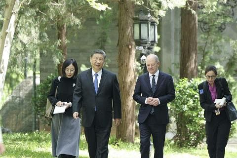 中国国家主席习近平（左二）4月16日在北京钓鱼台国宾馆与德国总理朔尔茨（右二）举行会谈后，一起散步前往午餐地点。（新华社）